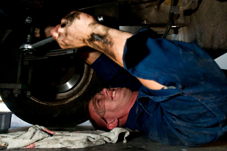 US Navy 090701-N-5821P-052 Aviation Support Equipment Technician 3rd Class Tony Perkins performs a routine oil change to a 42 Tow Tractor