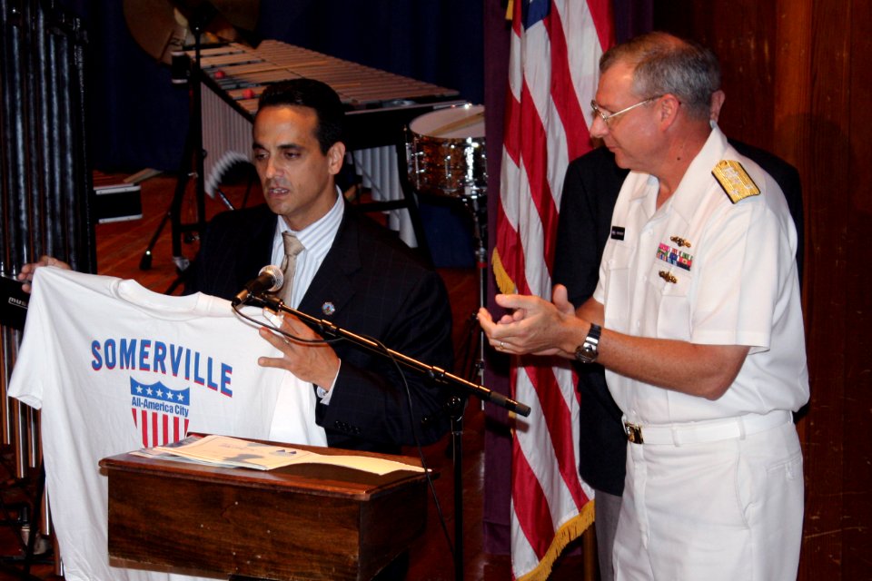 US Navy 090702-N-8110K-098 Mayor Joseph Curtatone presents his city's t-shirt to Vice Adm. Kevin M. McCoy, Commander, Naval Sea Systems Command prior to a performance by the U.S. Navy Band Northeast at Somerville High School