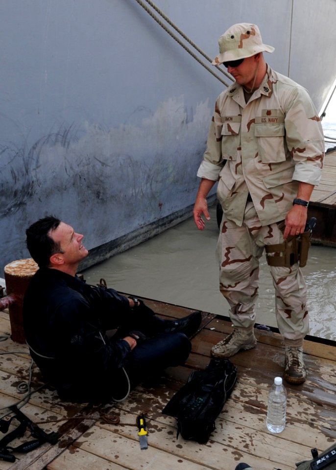 US Navy 090701-N-6814F-221 Senior Chief Navy Diver Craig Simon debriefs Navy Diver 2nd Class Greg Early after completing a dive around the hull of mine countermeasure ship USS Scout (MCM 8) at Umm Qasr, Iraq