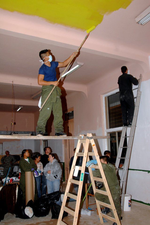 US Navy 090706-A-8397T-005 Ship Serviceman Rugin Sardon assigned to amphibious dock landing ship USS Oak Hill (LSD 51) paints the ceiling at Hospital Hogar Pineyro in Montevideo, Urugua