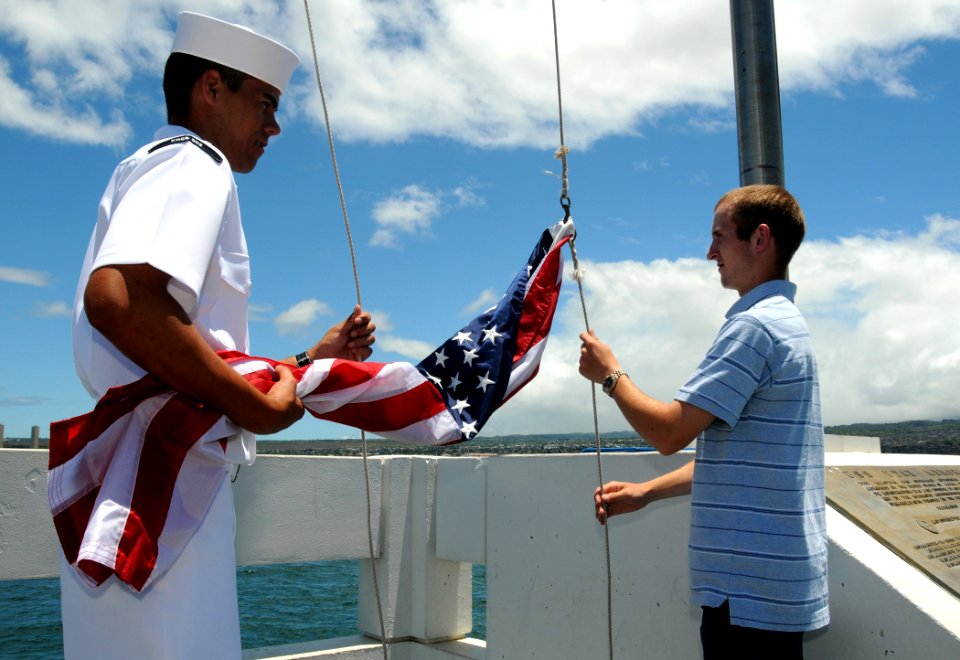 US Navy 090704-N-3666S-115 Builder Constructionman Apprentice Cleve Waiwaiole, assigned to Naval Mobile Construction Battalion (NMCB) 1, and Ethan Baatz raise the American flag over the USS Utah Memorial