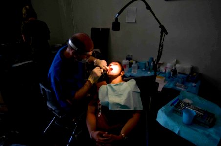 US Navy 090707-N-9689V-006 Mark Coussens, volunteer dentist of University of California, San Diegos Pre-dental Society, provides dental treatment to locals at a Pacific Partnership 2009 Medical Civic Action Project photo