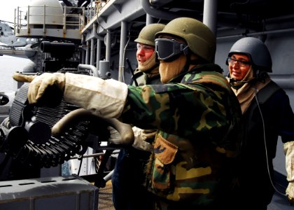 US Navy 090703-N-0515W-100 Gunner's Mate 3rd Class Darren Larson, Gunner's Mate 3rd Class William Payne and Aviation Ordnanceman 3rd Class Patrick Foster practice tactical engagements by simulating return fire from a 25mm gun