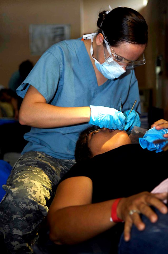 US Navy 090706-F-7923S-055 Army Spc. Shaylee Smith, a dental hygienist embarked aboard the Military Sealift Command hospital ship USNS Comfort (T-AH 20), cleans a Nicaraguan woman's teeth