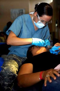 US Navy 090706-F-7923S-055 Army Spc. Shaylee Smith, a dental hygienist embarked aboard the Military Sealift Command hospital ship USNS Comfort (T-AH 20), cleans a Nicaraguan woman's teeth photo