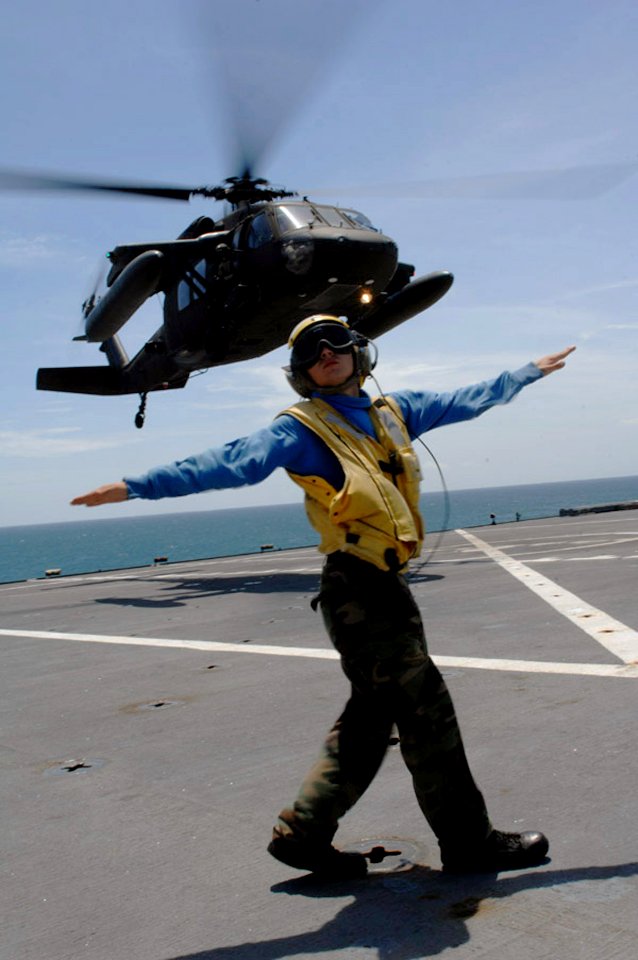 US Navy 090709-F-1333S-119 Aviation Boastswain's Mate 3rd Class Matthew Shaw directs a UH-60 Army Blackhawk helicopter