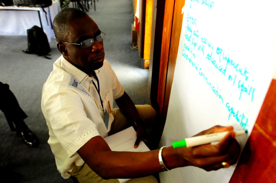 US Navy 090709-N-2420K-029 Senegal Navy Lt. Cmdr. Mamadou Ndiaye writes notes for his team during classroom training at the first Maritime Center of Excellence course held at the Bandari College in Mombasa
