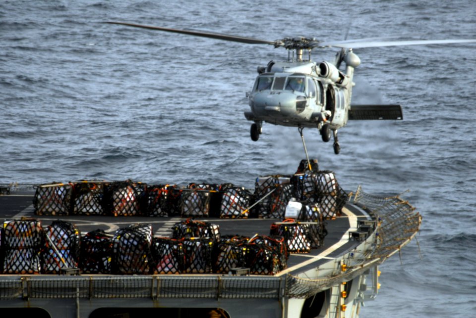 US Navy 090707-N-9132C-083 An MH-60S Sea Hawk assigned to the Black Jacks from Helicopter Sea Combat Squadron (HSC) 21, unloads cargo from the Military Sealift Command fast combat support ship USNS Rainier