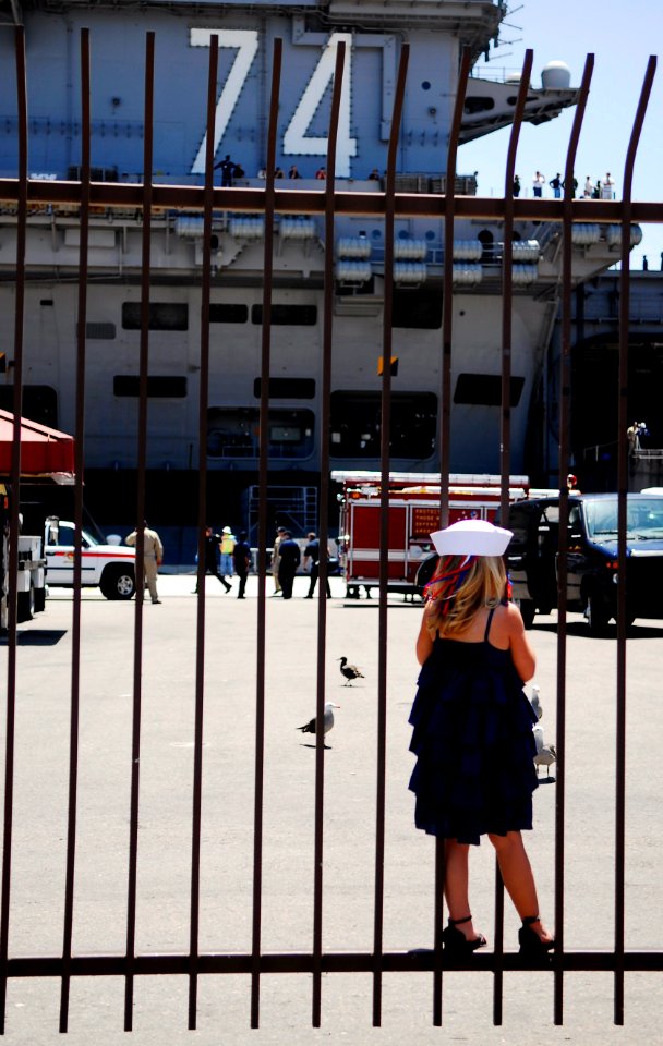 US Navy 090706-N-6538W-214 The daughter of Chief Aviation Structural Mechanic Kevin Sheppard from Lemoore, Calif. waits at the gate outside the pier to the aircraft carrier USS John C. Stennis (CVN 74) for her father