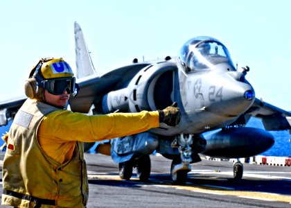 US Navy 090707-N-9950J-314 Aviation Boatswain's Mate (Handling) 3rd Class Luccas Rosario prepares to launch an AV-8B Harrier aircraft from the amphibious assault ship USS Essex (LHD 2)