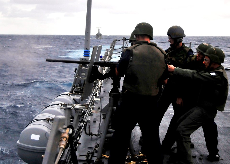US Navy 090709-N-2638R-002 Royal Australian Navy Midshipman Mark Esposito fires the .50 caliber machine gun aboard the Arleigh Burke-class guided-missile destroyer USS Mustin (DDG 89) during a gunnery exercise in the Pacific Oc