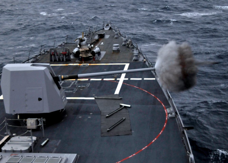 US Navy 090709-N-2638R-001 The five-inch gun aboard the Arleigh Burke-class guided-missile destroyer USS Mustin (DDG 89) is fired during a pre-aim calibration fire (PACFIRE) in the Pacific Ocean