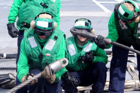 US Navy 090711-N-7456N-033 Aviation Boatswain's Mate (Equipment) Airman Shawn Greer works with ABEAN Kendrick and ABE3 Barnett on the flight deck of USS Carl Vinson (CVN 70) to detach the cable of the Ready Jet Barricade