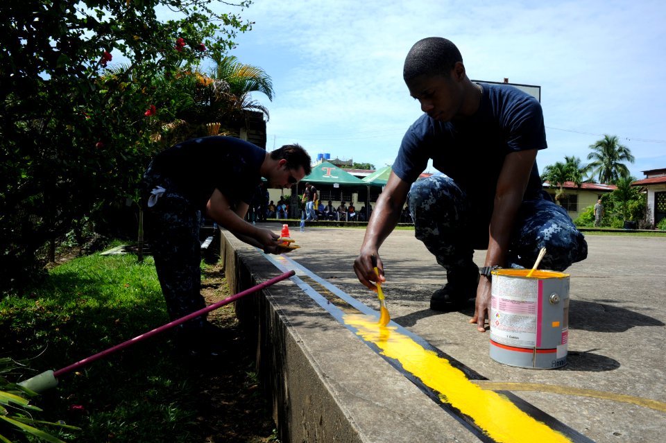 US Navy 100920-N-9964S-048 Quartermaster 2nd Class Shawn Dekle and Fireman Christopher Thomas paint a yellow line on a basketball court during a co