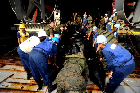 US Navy 100919-N-8335D-904 Sailors and Marines carry a combat rubber reconnaissance craft at the stern gate of the amphibious dock landing ship USS