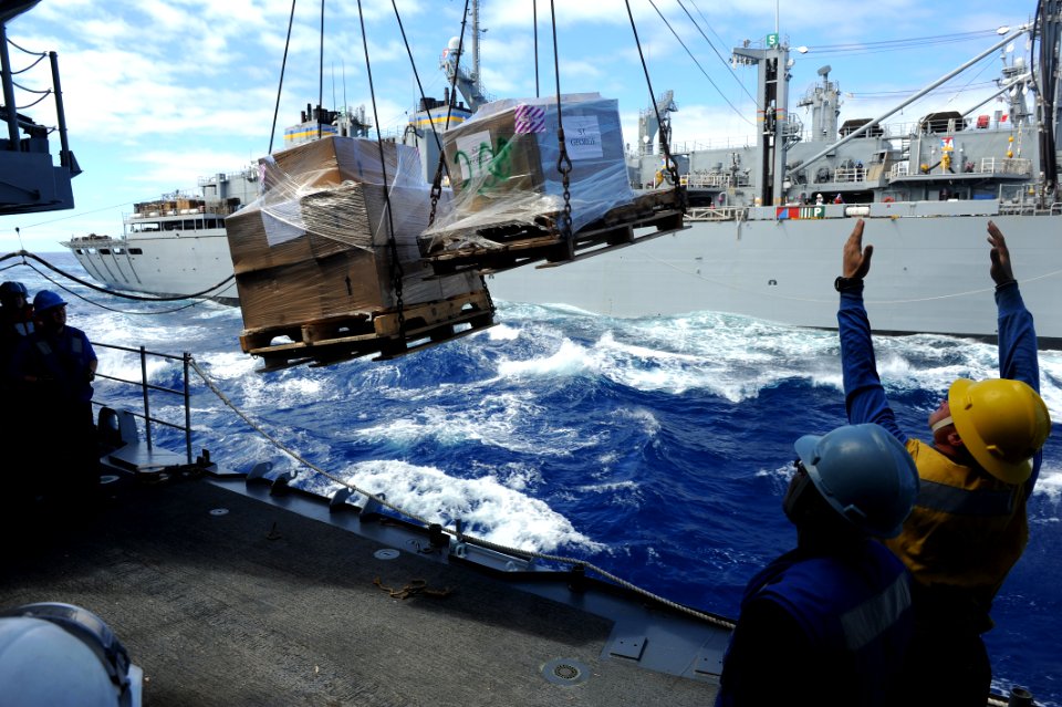 US Navy 100918-N-2821G-386 Boatswain's Mate 2nd Class Steve Rains, from Pauls Valley, Okla., guides pallets onto the deck of the guided-missile cru