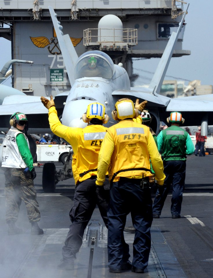 US Navy 100917-N-6362C-019 Flight deck directors guide an F-A-18C Hornet, assigned to the Checkerboards of Marine Fighter Attack Squadron (VMFA) 31