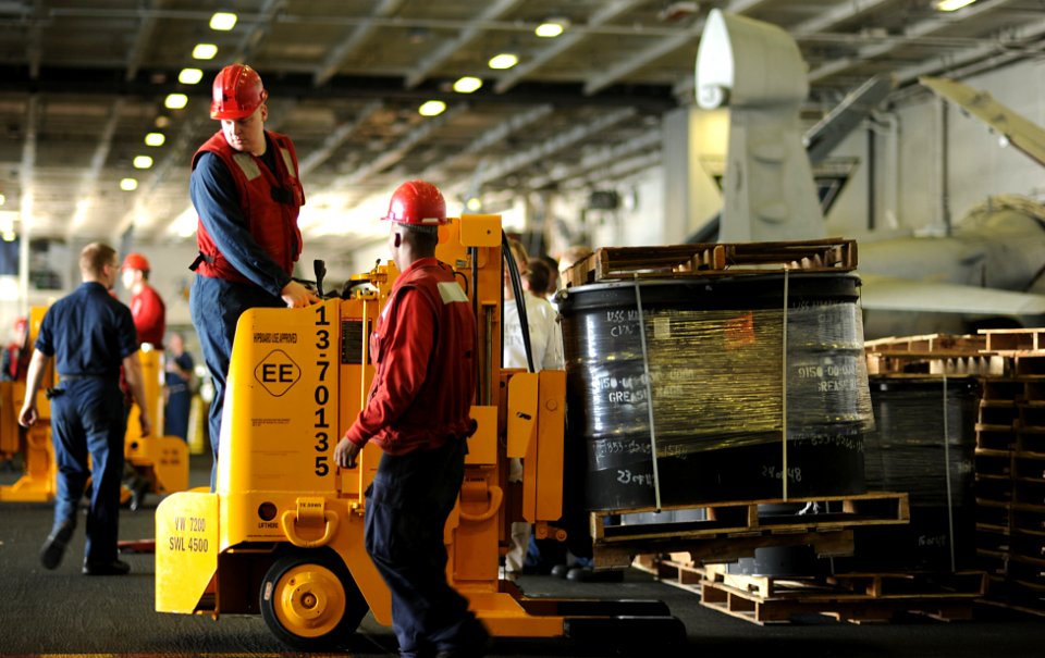 US Navy 100923-N-6362C-166 Aviation Ordnanceman 3rd Class Derek Koehler transports a supply pallet in the hangar bay aboard the aircraft carrier US
