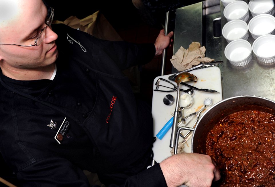 US Navy 100920-N-4973M-008 Culinary Specialist 2nd Class Jonathon K. Yates, from Greenville, N.C., stirs chili for the Abraham Lincoln Carrier Stri