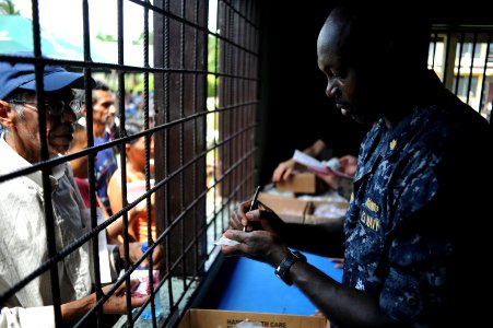 US Navy 100920-N-9964S-129 Lt. Benedict Baidoo writes a prescription for a Nicaraguan man during a Continuing Promise 2010 medical community servic photo