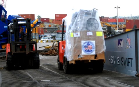 US Navy 100927-N-4971L-151 Hugh Grandstaff, third mate aboard High Speed Vessel Swift (HSV 2), moves a pallet of Project Handclasp Relief supplies photo