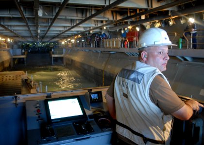 US Navy 100920-N-2218S-012 Chief Boatswain's Mate Michael Thurston backs a landing craft utility out of the well deck of the amphibious assault shi