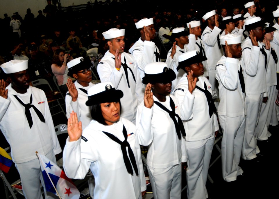 US Navy 100920-N-6632S-068 Sailors raise their right hands while reciting the oath of citizenship during a naturalization ceremony in the hangar ba