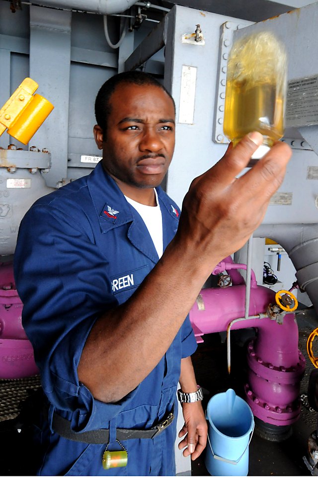 US Navy 100923-N-7680E-035 Machinist's Mate 2nd Class Antonio Green, from Yemassee, S.C., inspects a fuel sample for clarity aboard the multi-purpo