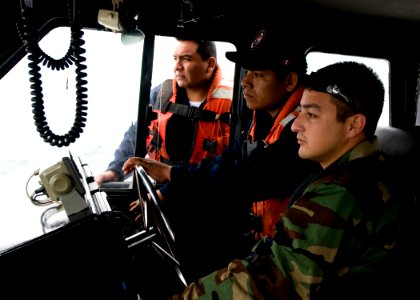 US Navy 100920-N-9095H-061 Boatswain's Mate 2nd Class Daniel Mendoza, right, supervises a Peruvian coast guardsman's coxswain skills during coxswai