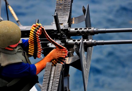 US Navy 100920-N-7948R-069 Gunner's Mate 3rd Class Matthew Montalbano loads a .50-caliber machine gun during a small craft action team exercise abo