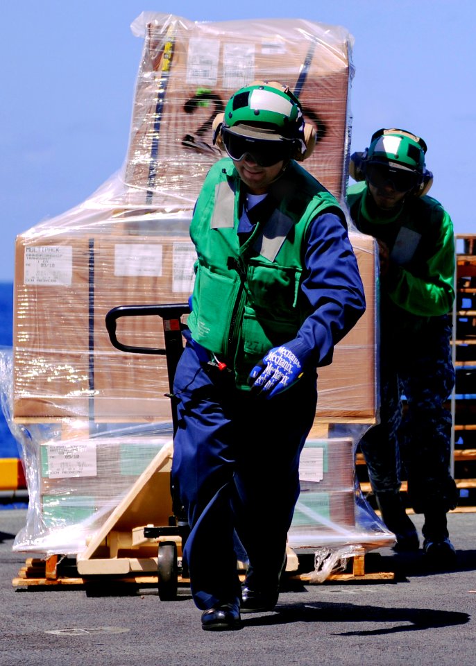 US Navy 100925-N-9950J-218 ogistics Specialist 1st Class Julio Andrade moves supplies aboard the forward-deployed amphibious assault ship USS Essex