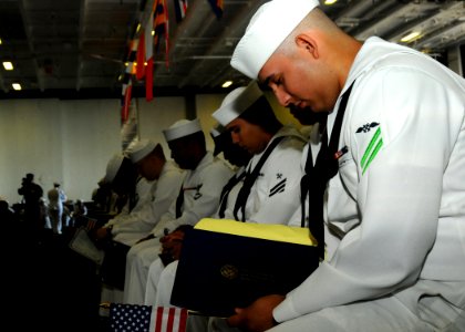 US Navy 100920-N-7908T-053 A Sailor bows his head during the benediction for a naturalization ceremony aboard the aircraft carrier USS George H.W