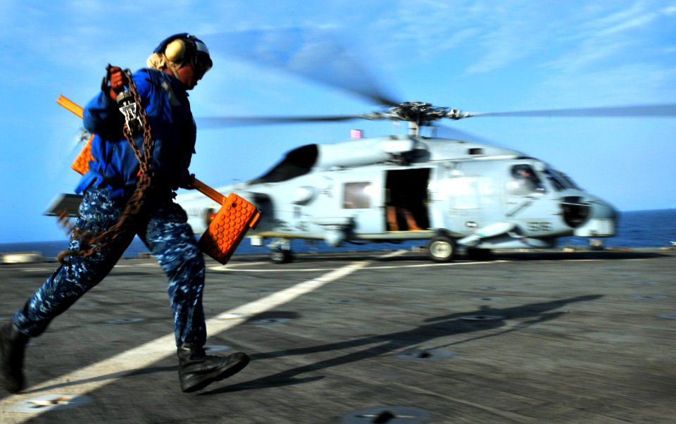US Navy 100923-N-7948R-443 Boatswain's Mate Seaman Allison Mulligan hurries across the flight deck after removing the chocks from an MH-60S Sea Haw
