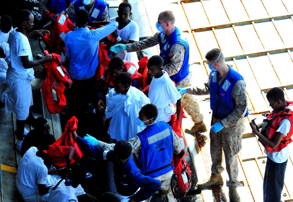 US Navy 100929-N-7948R-306 Sailors and Marines help rescued persons remove their life jackets as they embark aboard USS Pearl Harbor (LSD 52)
