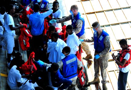 US Navy 100929-N-7948R-306 Sailors and Marines help rescued persons remove their life jackets as they embark aboard USS Pearl Harbor (LSD 52)