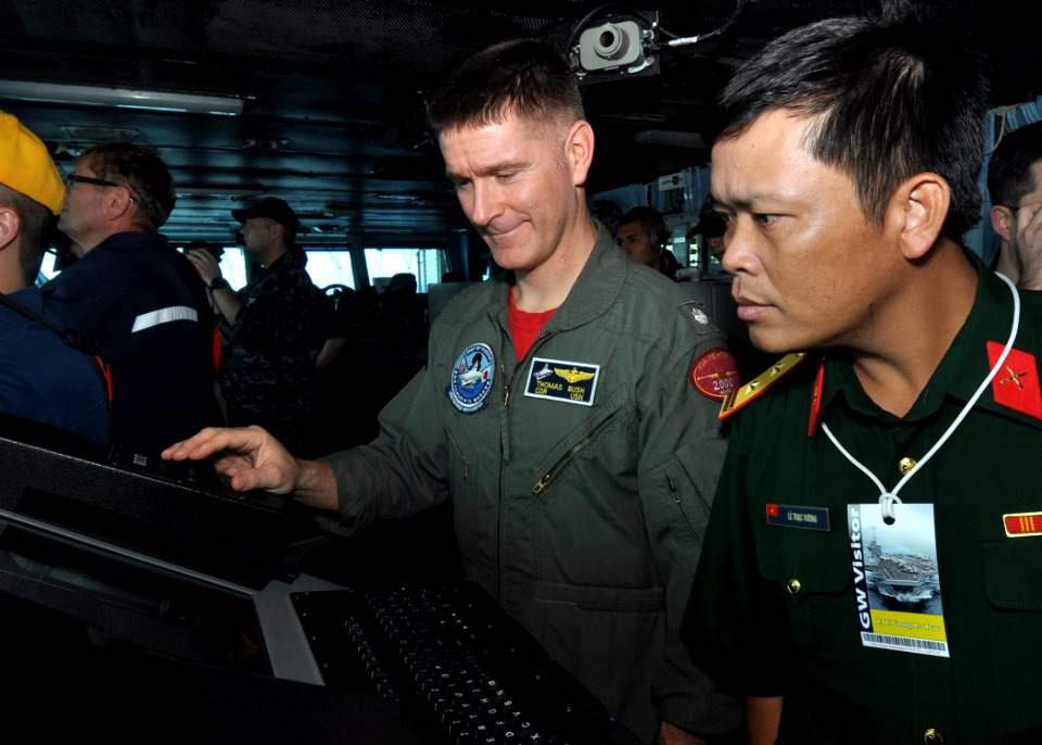 US Navy 101001-N-2013O-056 Cmdr. Thomas Bush, center, explains the purpose of a radar console to Lt. Col. Vuong Le Trac of the Vietnamese armed for