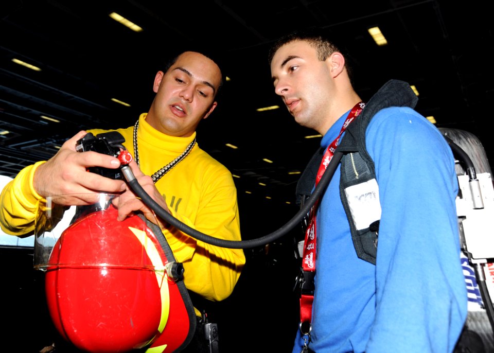 US Navy 100926-N-3885H-064 Aviation Boatswain's Mate (Handling) Airmen Andres Garcia, left, and Anthony Gallegos train with firefighting equipment