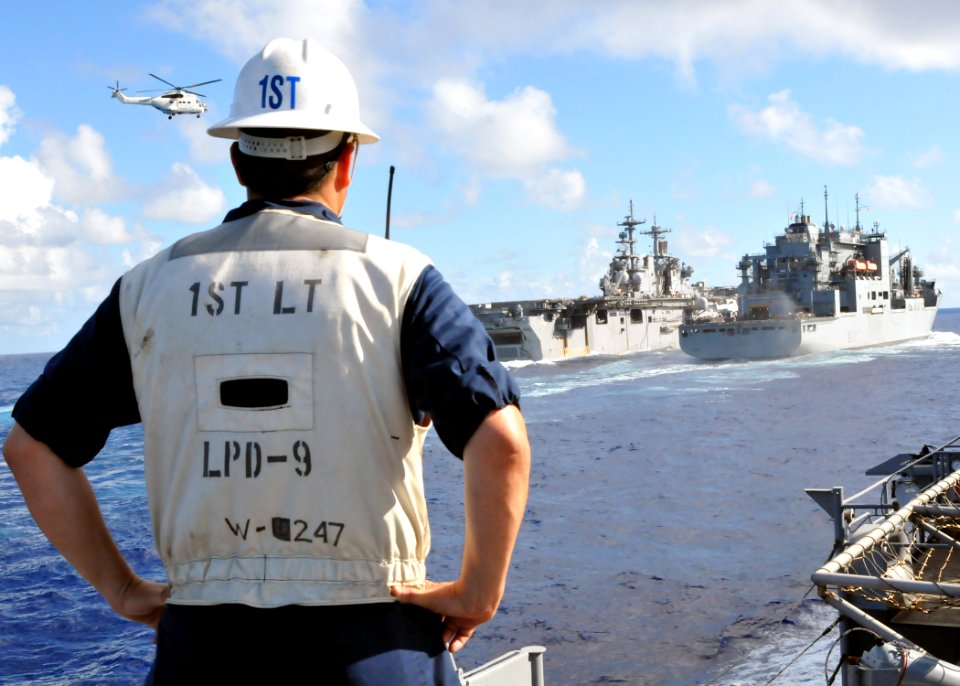 US Navy 101002-N-8113T-047 An officer watches the Wasp-class amphibious assault ship USS Essex (LHD 2), left, conduct a vertical replenishment with