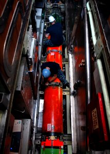 US Navy 100923-N-7705S-053 Sonar Technician 2nd Class Earl Patterson and Machinist's Mate Fireman Michael McCord tighten the locking straps o
