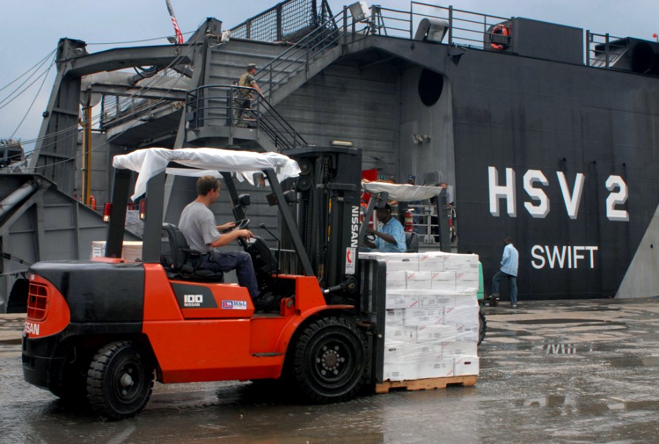 US Navy 100927-N-4971L-053 Hugh Grandstaff, third mate aboard High Speed Vessel Swift (HSV 2), moves a pallet of Project Handclasp Relief supplies