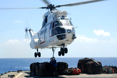 US Navy 100925-N-8335D-545 Damage Controlman Fireman Jasmine Bly and Seaman Arthur Hubbard hook a pole pendant to a Military Sealift Command SA-330