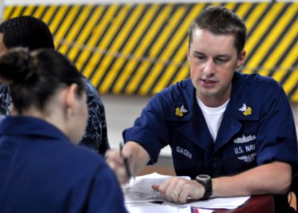 US Navy 100929-N-2013O-016 Information Systems Technician 1st Class Jason Gagen, from Sandusky, Ohio, explains an Enlisted Surface Warfare Speciali