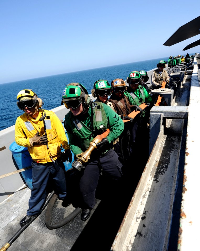 US Navy 100927-N-4135M-069 Sailors and Marines stand by as a backup fire hose team during a fire drill aboard the aircraft carrier USS Harry S. Tru
