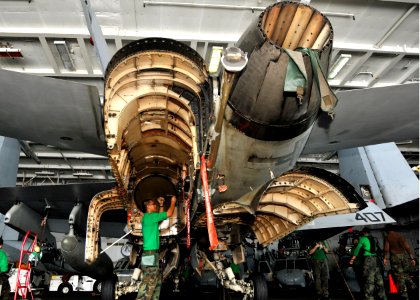 US Navy 100929-N-7103C-019 Aviation Structural Mechanic (Equipment) Airman Frederick Copuyoc removes bolts from the access panel of an F-A-18C Horn