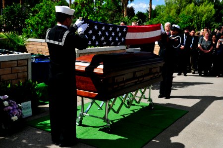 US Navy 101004-N-3659B-412 Engineman 1st Class Maynard Bagan, left, and Yeoman 2nd Class Felicia Tate fold the national ensign during the funeral o