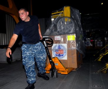 US Navy 100927-N-4971L-160 Seaman Robert Burgett, embarked aboard High Speed Vessel Swift (HSV 2), moves a pallet of Project Handclasp Relief suppl photo