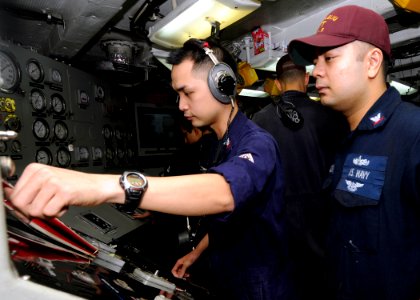 US Navy 100927-N-3729D-104 Electrician's Mate 2nd Class Ryan Manalo, left, conducts an electrical ground test under the supervision of Electrician'