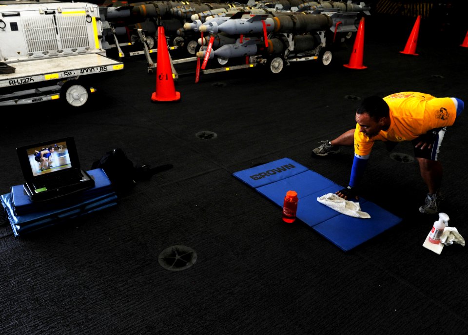 US Navy 101005-N-6427M-055 Chief Aviation Boatswain's Mate (Handling) Donovan Mahiai, from Walanae, Hawaii, uses a workout video as part of his phy
