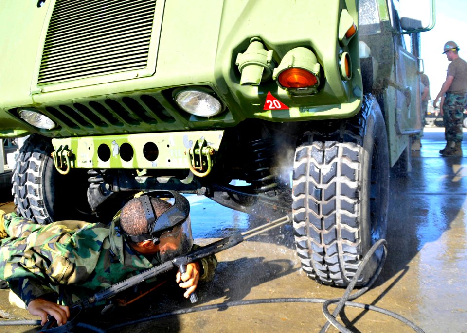 US Navy 100929-N-4440L-006 Utilitiesman Constructionman Apprentice Victor Carr cleans a Humvee with a pressure washer at Naval Construction Battali