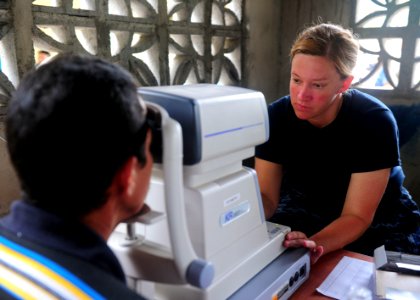 US Navy 101001-N-1531D-107 Hospital Corpsman 1st Class Jessica Johnson checks a man's eye prescription during a Continuing Promise 2010 medical com